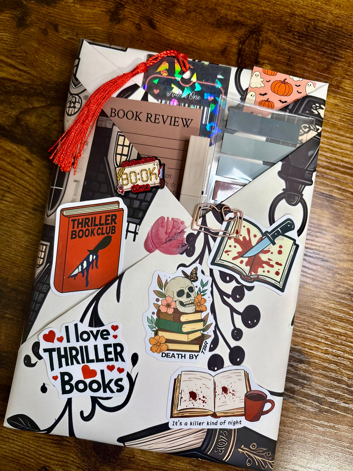 Example Blind Date with a Book hardcover kit from The Midnight Bookmark featuring a wrapped mystery book and assorted bookish extras